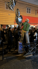 Night crowd gathers at Tabac Progres, person on bicycle trailer