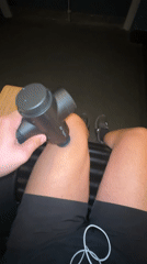 Person uses massage gun on thigh in London