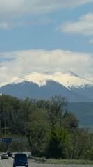 Snow-capped mountain viewed from Bulgarian highway under clear skies