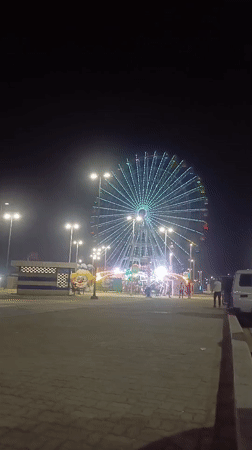 Illuminated Ferris wheel operates at night in Macuto, Venezuela