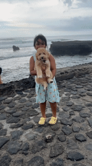 Young girl holds puppy in North Kuta, Indonesia