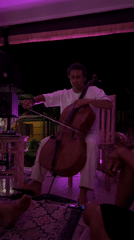 Cellist performs in purple-lit setting in Abang, Indonesia