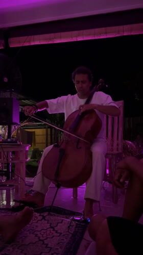 Cellist performs in purple-lit setting in Abang, Indonesia