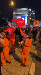 Nighttime protest in Tel Aviv features flags, signs, orange jumpsuits