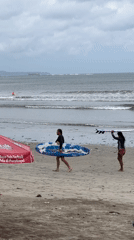 Early morning beach activity and worker break captured in Kuta