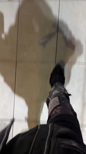 Person in distressed pants walks on tiled surface in Buenos Aires