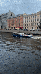 Tour boat carries passengers along Saint Petersburg canal