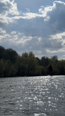 Person hydrofoils on Moscow waterway in black wetsuit