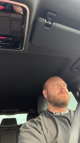 Behind the wheel in Chaikovsky, rocking a Los Angeles tee
