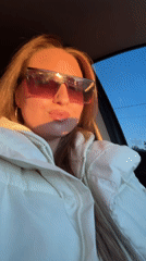 Woman makes playful faces while sitting in car in Omsk