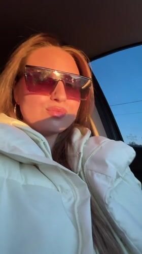 Woman makes playful faces while sitting in car in Omsk