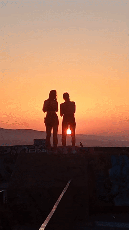 Sunset watch over Barcelona from a graffiti-tagged hilltop viewpoint