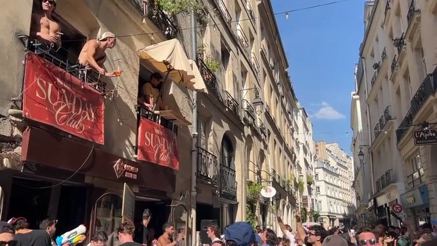 Sunny Paris street party spills onto balconies mid-afternoon