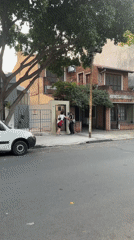 Two people stand on Buenos Aires sidewalk near gate