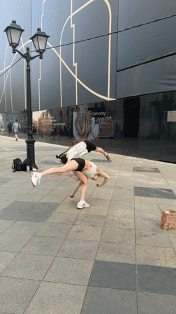 Two women perform backflips in Moscow public square