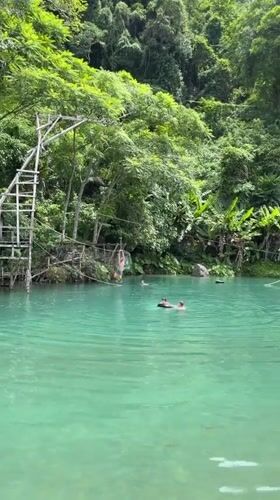 Ziplining into a turquoise jungle pool in Ban Nampoun, Laos