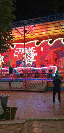 Fergana City's nightlife strip: rides, restaurants, and neon lights