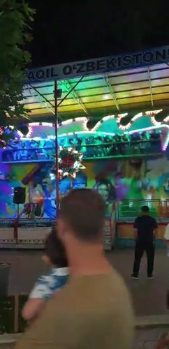 Fergana City's nightlife strip: rides, restaurants, and neon lights