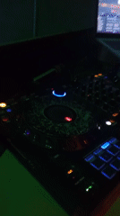 DJ performance captured in dimly lit room with controllers