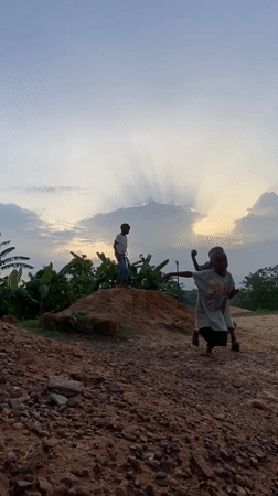 Children play on dirt mound in Ogbu, Nigeria