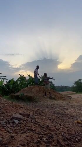 Children play on dirt mound in Ogbu, Nigeria