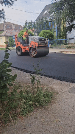 Road crew resurfaces a Hévíz street with paver and roller