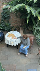 Woman pets orange cat in Vicente López backyard