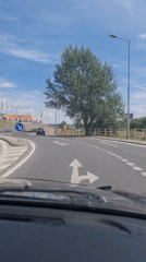 Driver navigates Bratislava roundabout during morning traffic