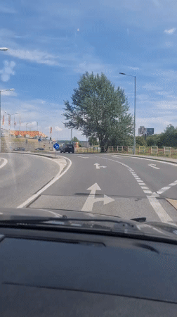 Driver navigates Bratislava roundabout during morning traffic
