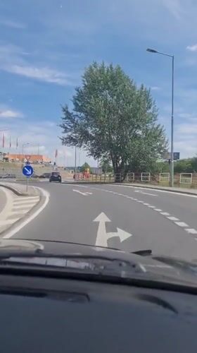 Driver navigates Bratislava roundabout during morning traffic