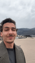 Man takes selfies at Boreti beach on cloudy morning