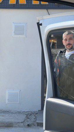 Man handles bag while closing van door in Karaburun