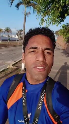 Man with tourism lanyard walks through sunny Porlamar courtyard