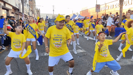 Carnival parade with dancers in promotional shirts in Tacna