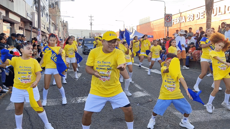 Carnival parade with dancers in promotional shirts in Tacna