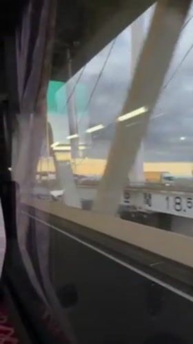 Passenger films white bridge structure from moving vehicle in Yokohama