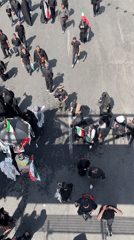 Crowd in black carries Iranian flags through Tehran streets