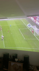 Young men watch soccer penalty kick on backyard projector
