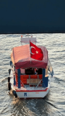 Turkish-flagged boat crosses Istanbul waters near modern bridge