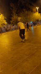 Young people skateboard, play soccer in Barcelona square at night