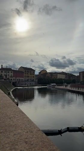 Quiet canal moment captured in Milan under cloudy skies