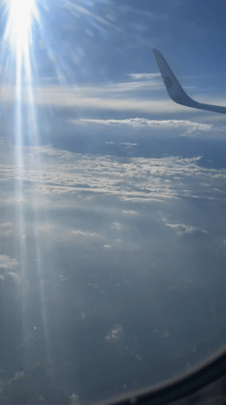 Passenger films sunlit cloudscape from airplane over Guanghan City