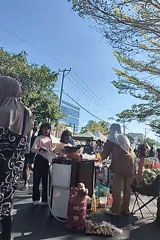 Busy street food market scene in Kupang, Indonesia