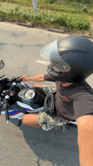 Motorcyclist rides through green roadside area in Đà Nẵng