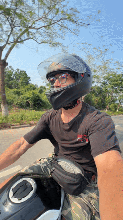 Motorcyclist rides through green roadside area in Đà Nẵng