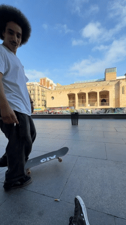 Skateboarders perform tricks in Barcelona plaza during afternoon session