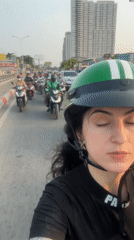 Woman takes selfie during Ho Chi Minh City motorcycle traffic