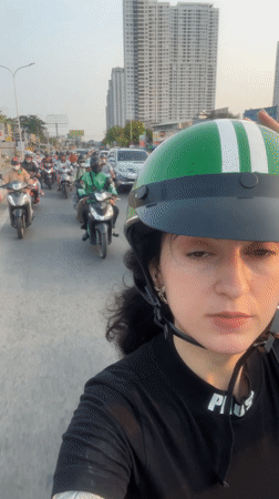 Woman takes selfie during Ho Chi Minh City motorcycle traffic