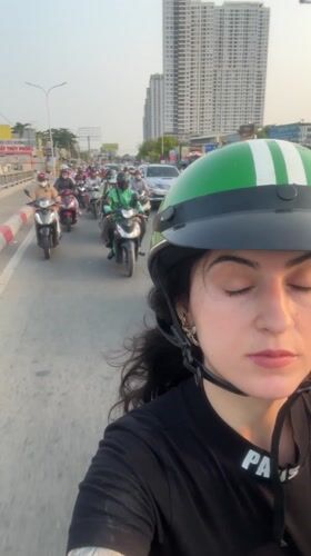 Woman takes selfie during Ho Chi Minh City motorcycle traffic