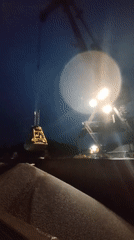 Nighttime crane operations unload gravel at Shalsky port facility